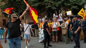 Dos constitucionalistas ondean banderas de España frente a los independentistas.