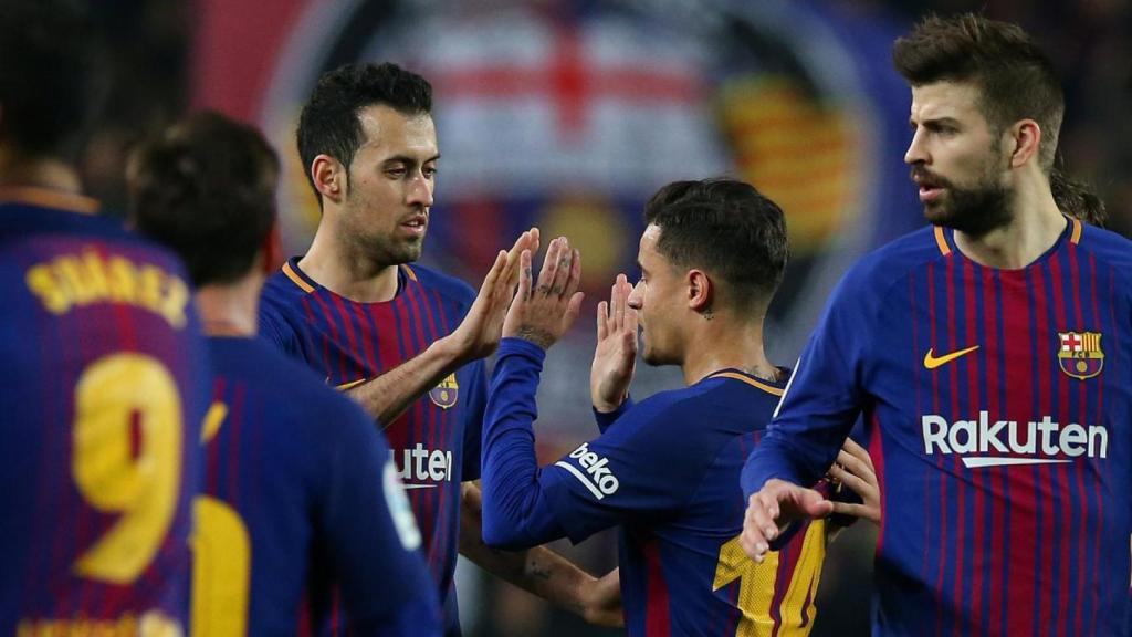 Busquets y Piqué, junto a Coutinho en un partido del Barcelona