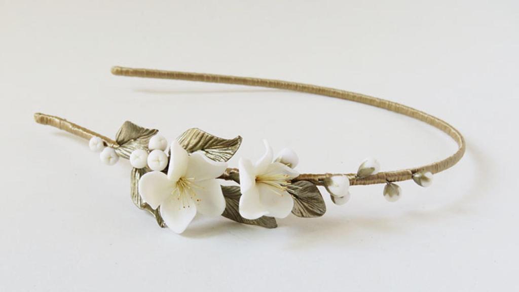 Tocado tipo diadema con flores en un lateral de 'El Taller de Bagatela'.
