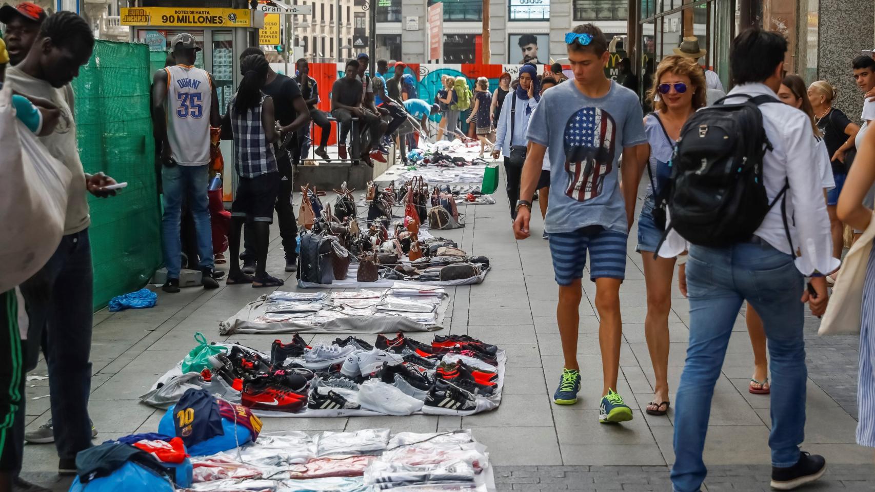 Manteros en las aceras de Gran Vía en Madrid.