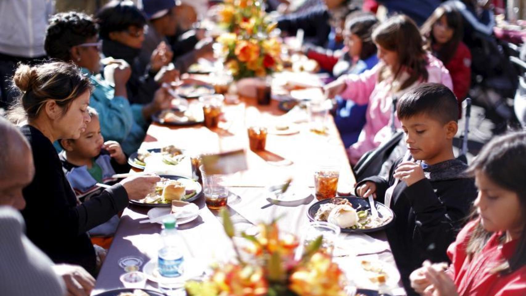 Familias comen juntas en acción de gracias.