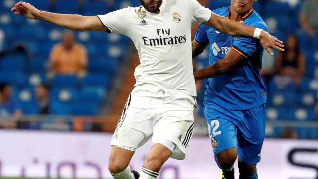 Karim Benzema, pugna por un balón con un jugador del Getafe.