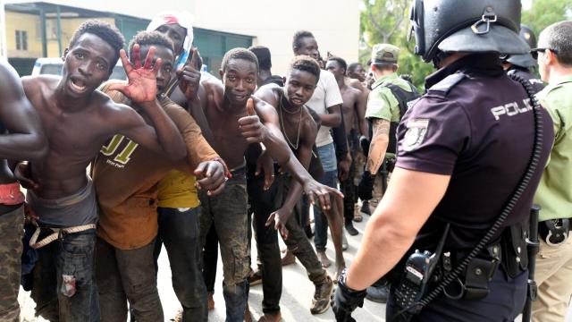 Varios inmigrantes subsaharianos celebran el salto con éxito a la valla de Ceuta.