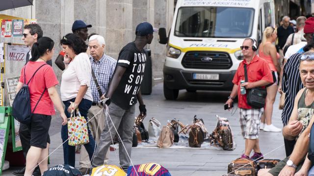 Uno de los manteros observa inquieto la furgoneta de la policía.