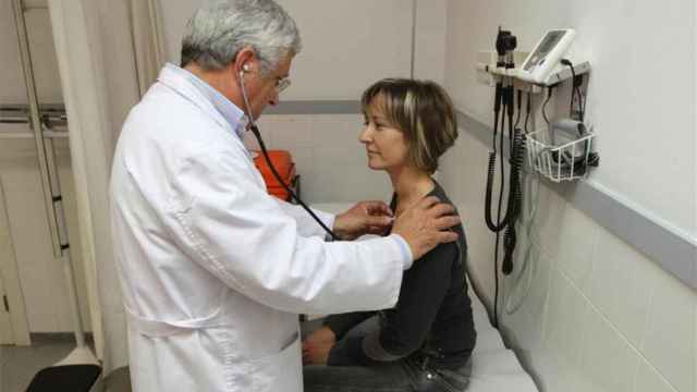 Un médico de Atención Primaria ausculta a una paciente en su consulta.