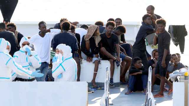 Inmigrantes esperan a bordo del barco 'Diciotti', en el puerto de Catania (Italia).