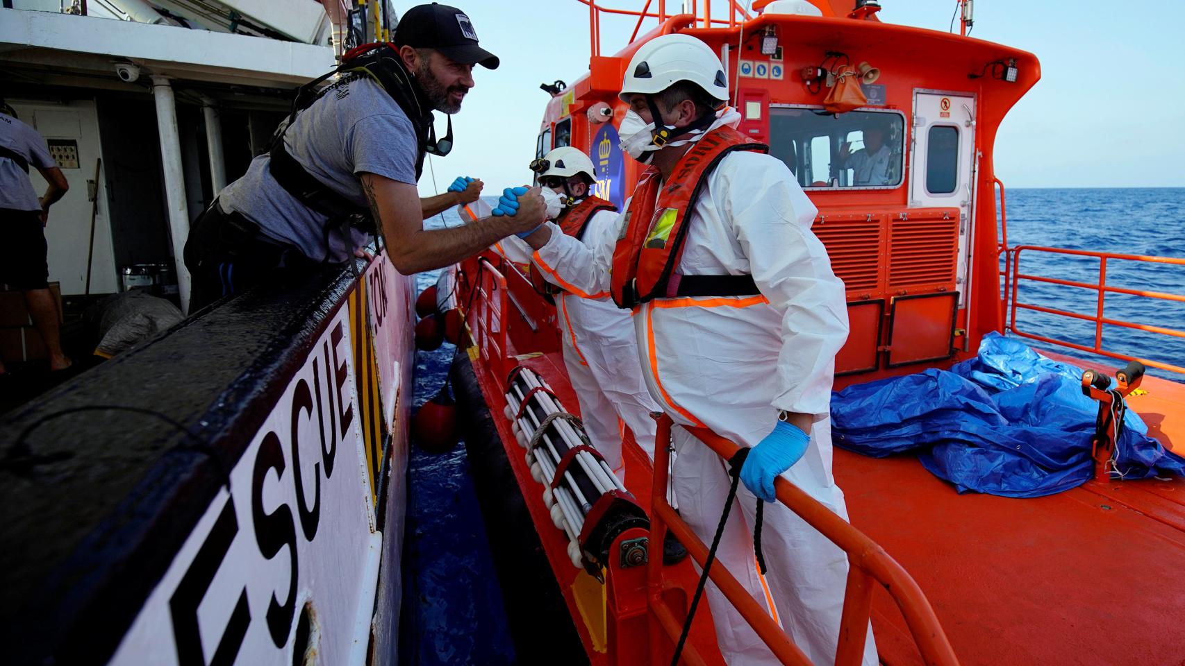 Miembros de la ONG Proactiva Open Arms se felicitan tras un rescate en el Mediterráneo.