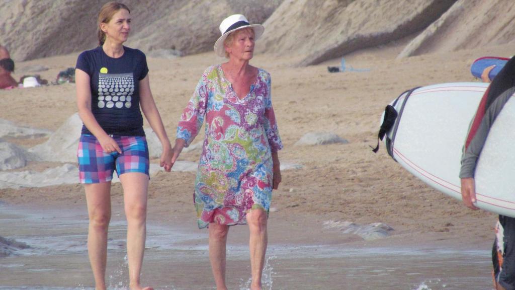 La infanta Cristina y Claire Liebaer paseando de la mano por la orilla del mar.