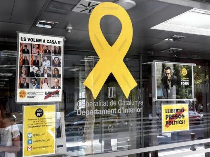 Lazo amarillo y carteles a la entrada del Departamento de Interior de Cataluña.
