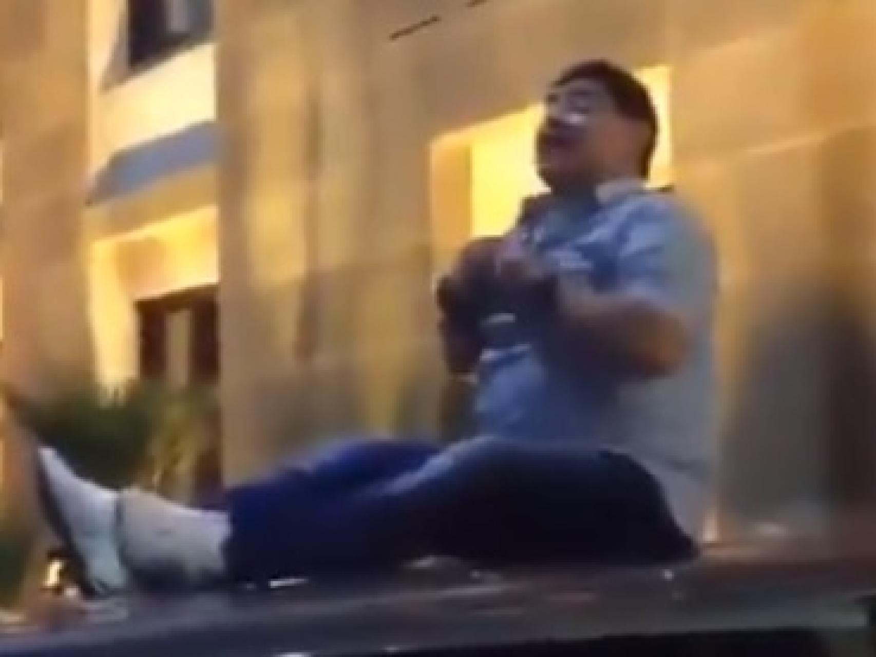 Maradona sentado encima de un coche