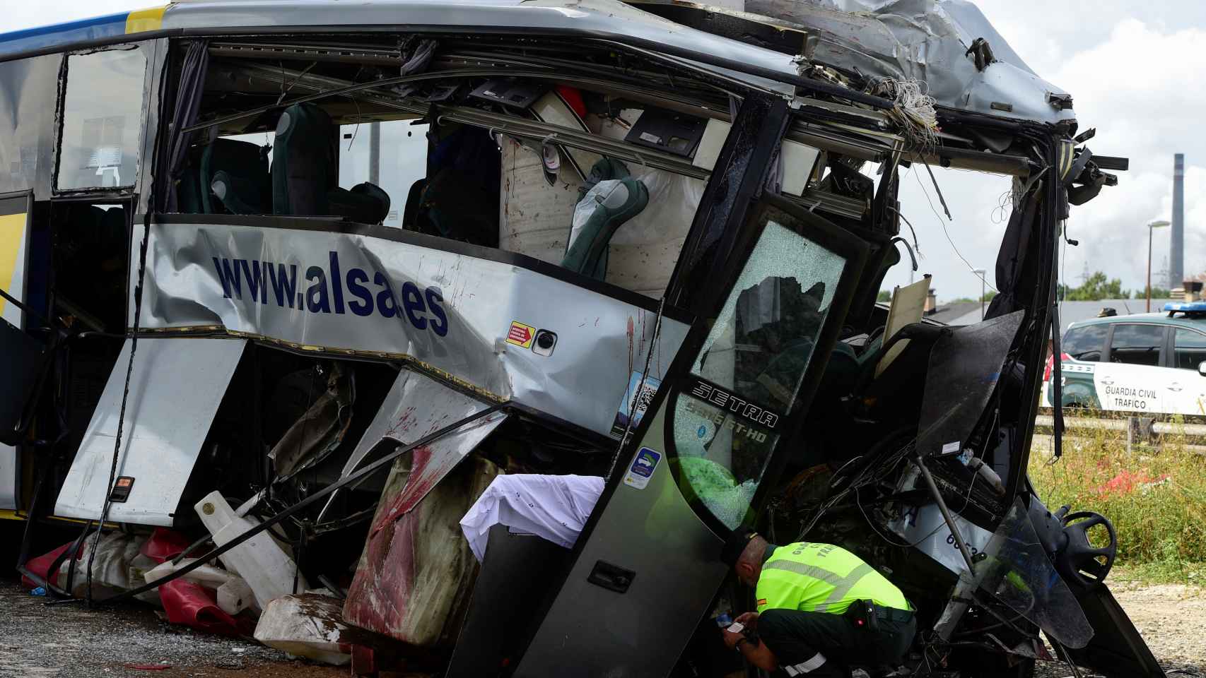 Un policía rebusca entre los escombros del autbús. | REUTERS