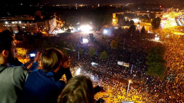 Unos jóvenes observan el concierto en Chemnitz desde las alturas.