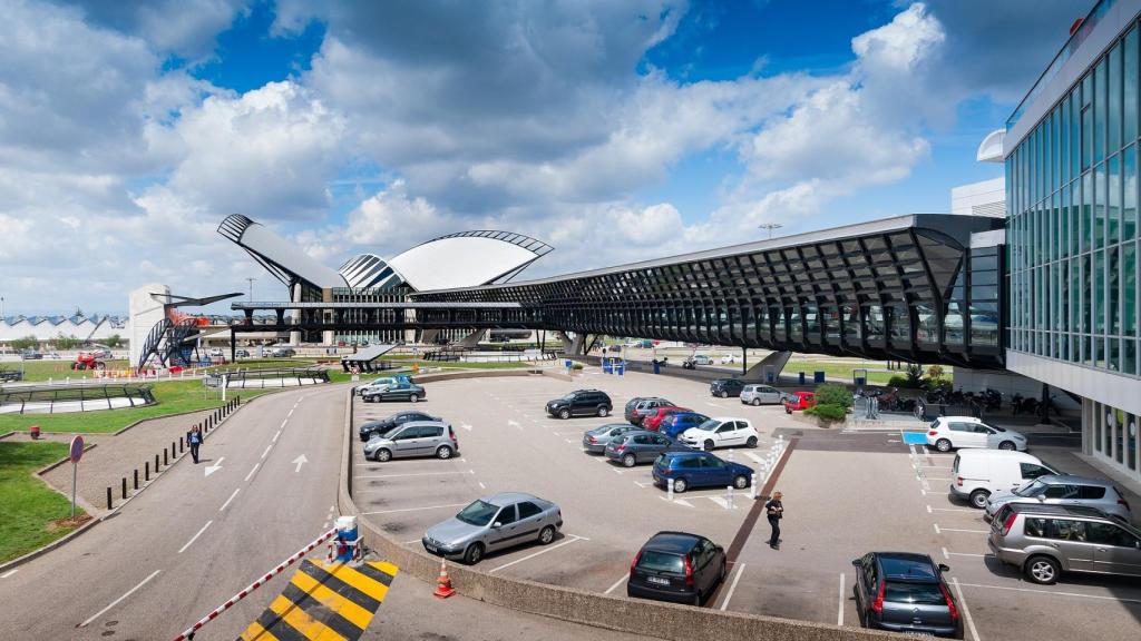 Algunos coches junto a las pistas en el aeropuerto de Lyon.