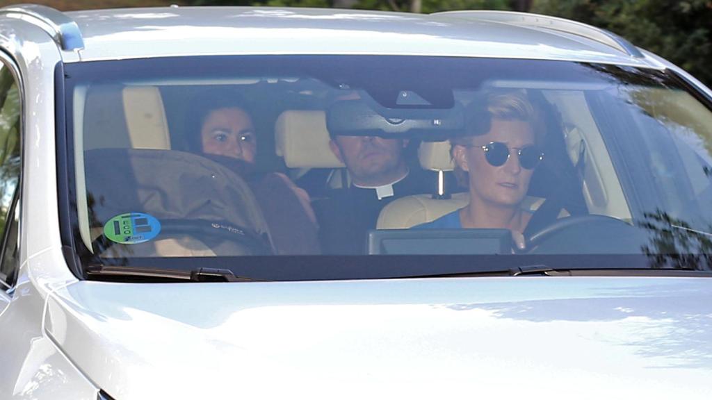 María Zurita en el interior del coche junto al párroco que ha oficiado el acto religioso.