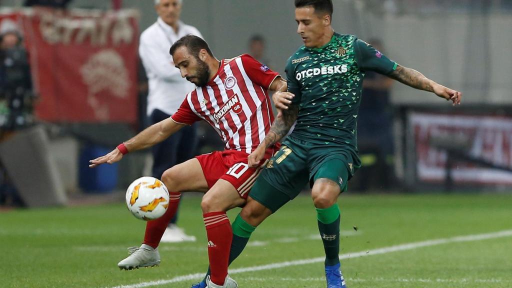 Dos jugadores pugnan por un balón en el  Olympiacos - Betis