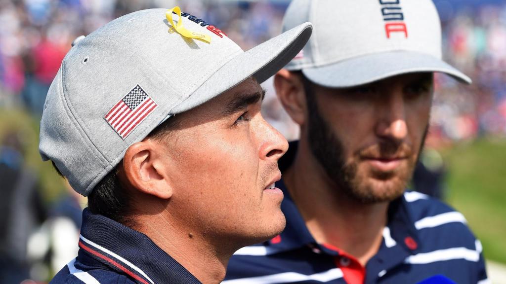 Los estadounidenses Dustin Johnson (d) y Rickie Fowler (i) conversan con periodistas tras su victoria