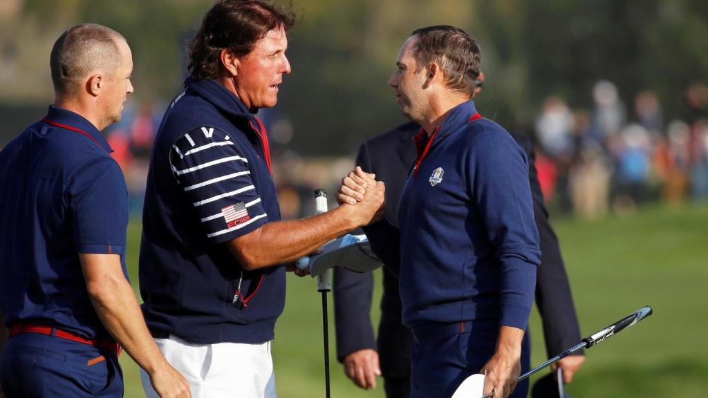 El español del equipo europeo Sergio García y el sueco Alex Noren (izda) saludan al estadounidense Phil Mickelson (c)