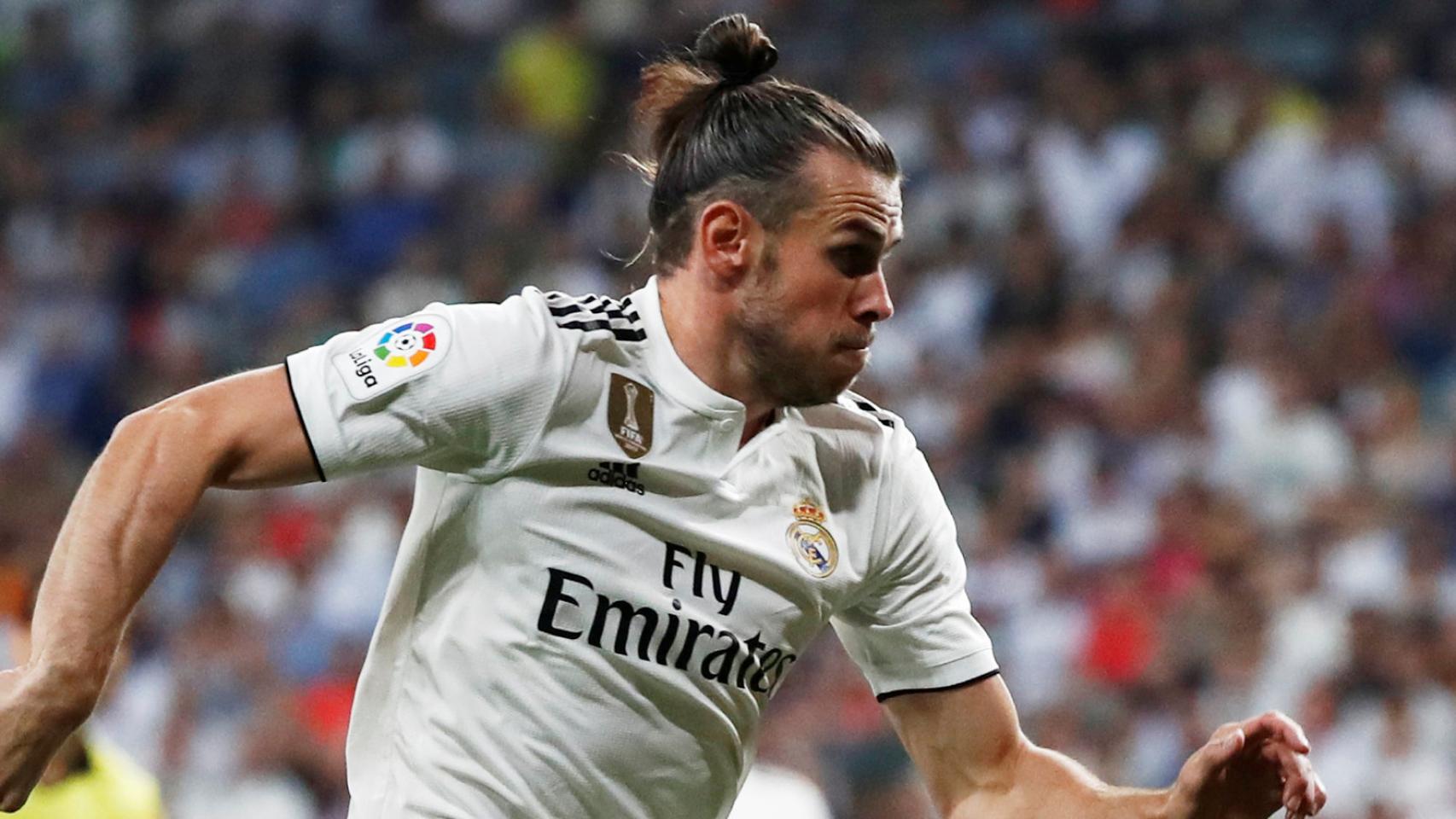 Bale disputa un balón con Godín.