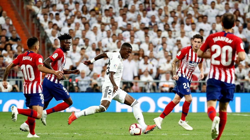 Vinicius rodeado de cuatro jugadores del Atlético en su debut oficial con el Real Madrid