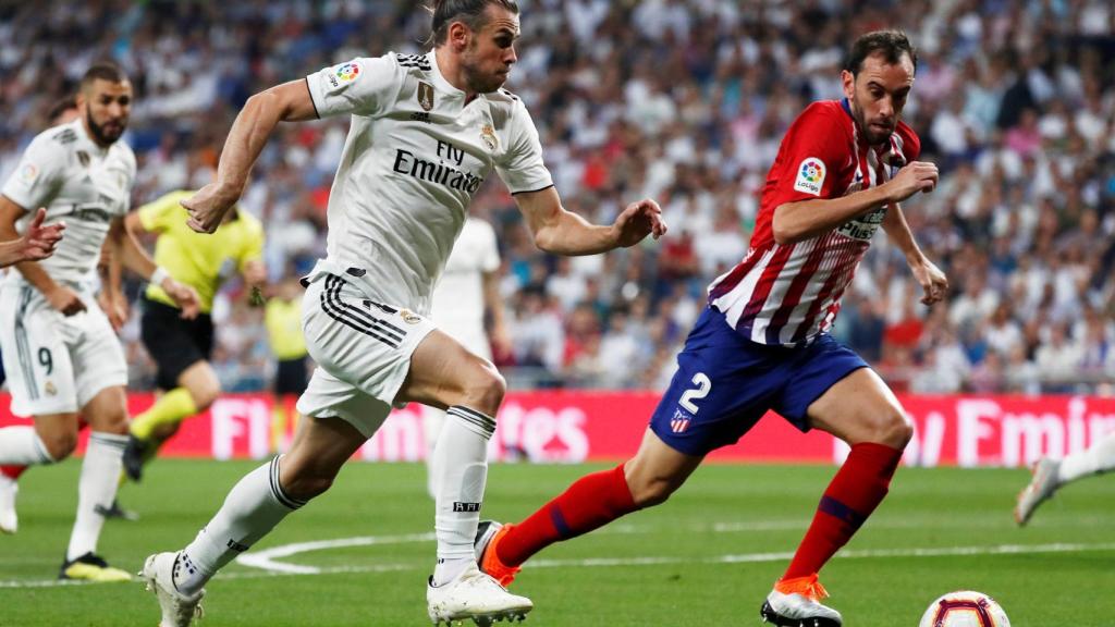Gareth Bale, conduce el balón ante el defensa brasileño del Atlético de Madrid, Filipe Luis