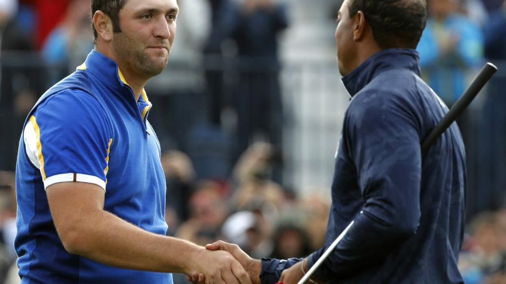 El jugador español del equipo de Europa de la Ryder Cup Jon Rahm es felicitado por el americano Tiger Woods