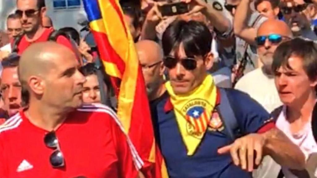 El joven de la estelada (derecha) agrede al agente de la Guardia Civil, de camiseta roja (izquierda).