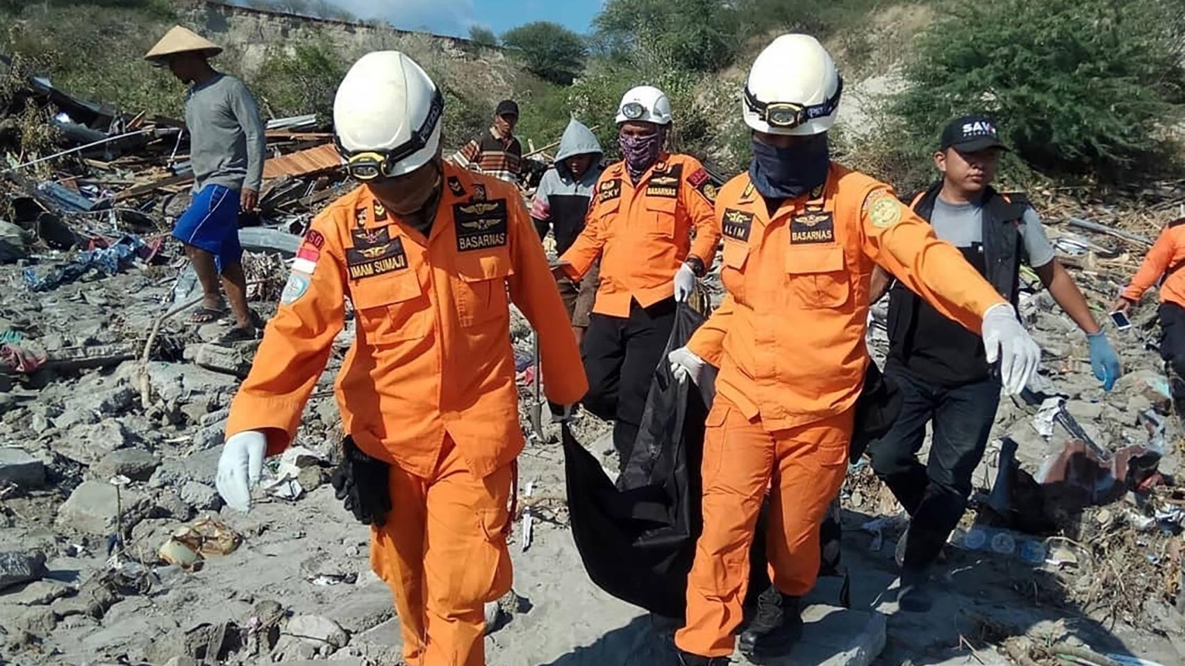 Varios miembros del personal de rescate cargan con el cuerpo de una víctima mortal en Donggala.