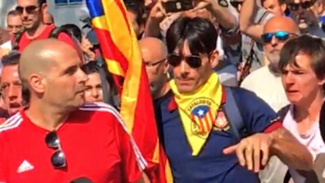 El joven de la estelada (derecha) agrede al agente de la Guardia Civil, de camiseta roja (izquierda).