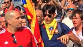 El joven de la estelada (derecha) agrede al agente de la Guardia Civil, de camiseta roja (izquierda).