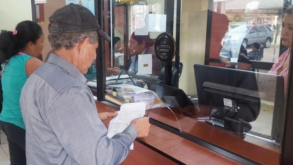 Un ciudadano paga impuestos en la ventanilla.