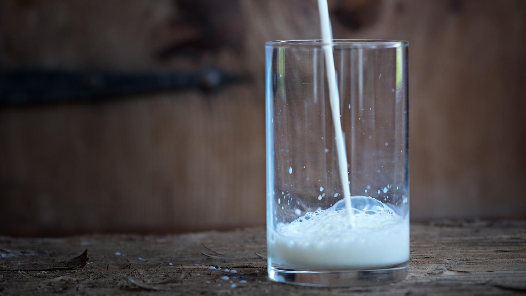 Un chorro de leche cayendo sobre un vaso.