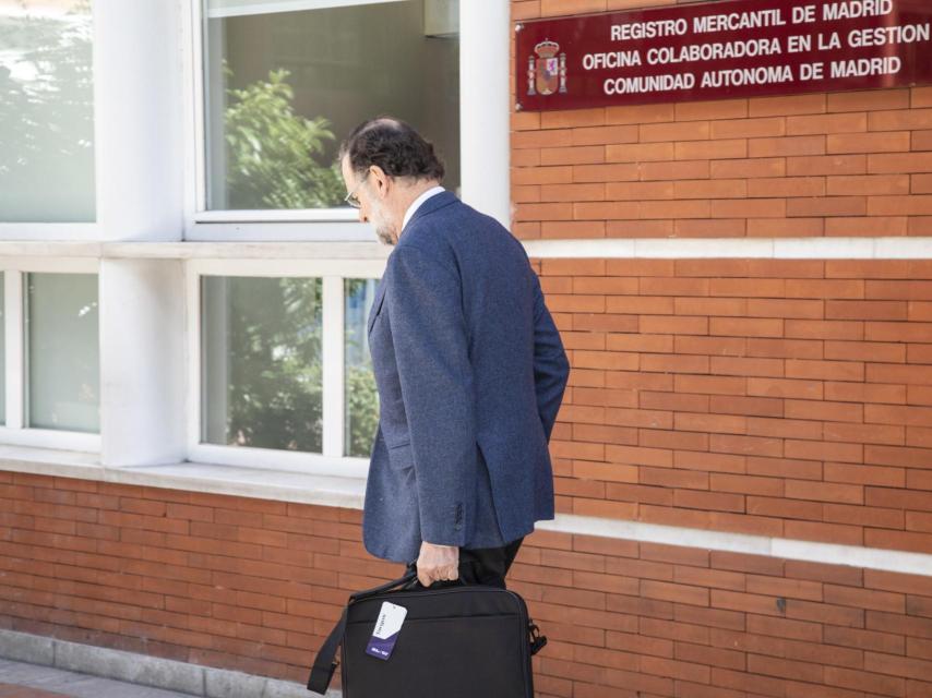El expresidente del Gobierno, Mariano Rajoy, saliendo del trabajo aún con la etiqueta en el nuevo maletín