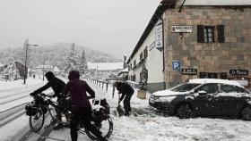 Una pareja de turistas se disponen a continuar su camino en bicicleta en Roncesvalles (Navarra).