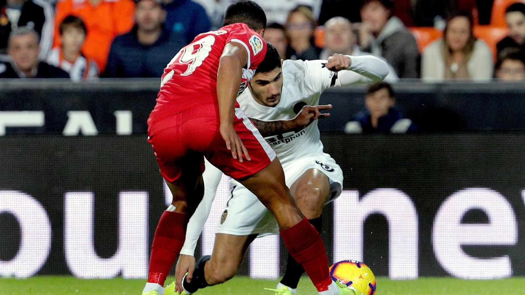 Guedes y Pedro Porro pelean por un balón