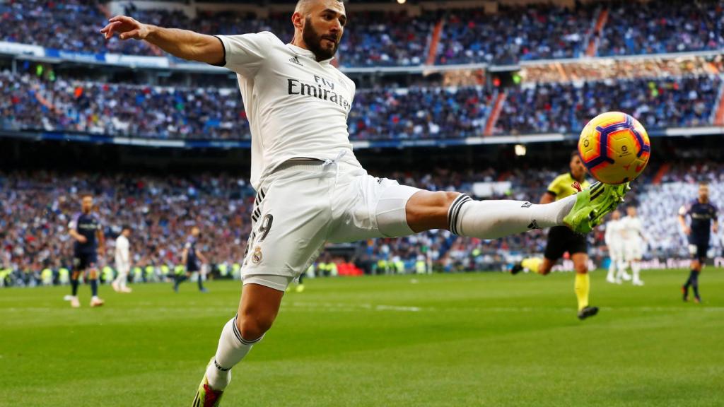 Karim Benzema intenta que un balón no salga por la banda