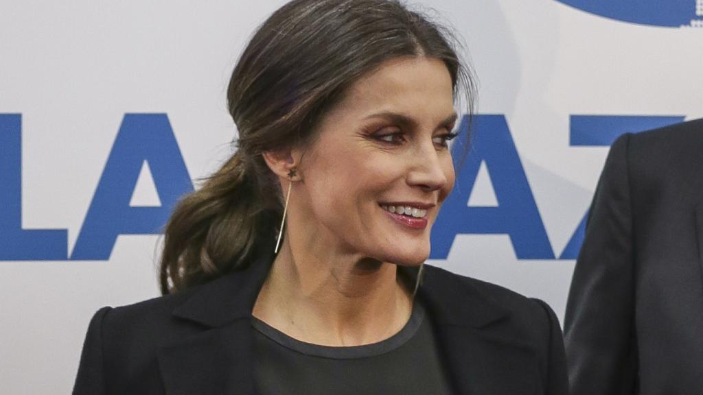 La reina Letizia con abrigo negro 'oversize' por encima de los hombros.