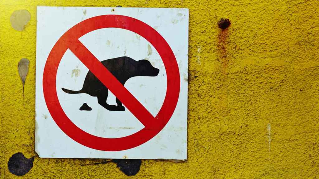 Una señal de la prohibición de que los perros hagan caca en un parque.