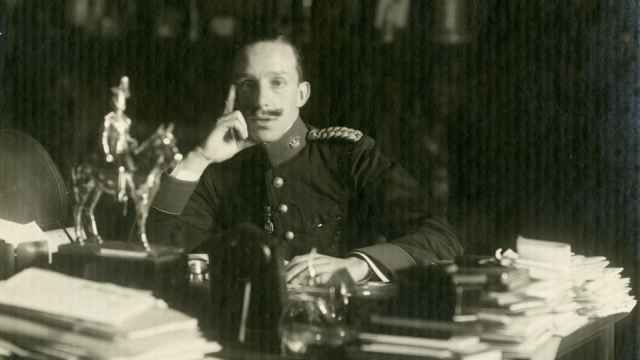 Retrato de Alfonso XIII sentado ante su mesa de despacho con el uniforme del Regimiento Inmemorial del Rey.