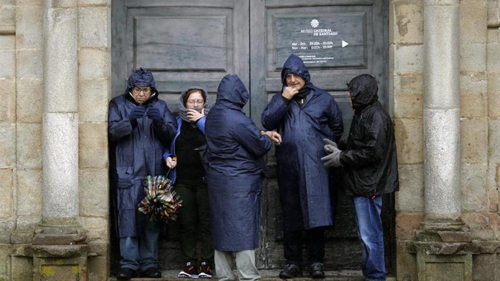 Los turistas bajo la lluvia esta mañana en Santiago de Compostela.