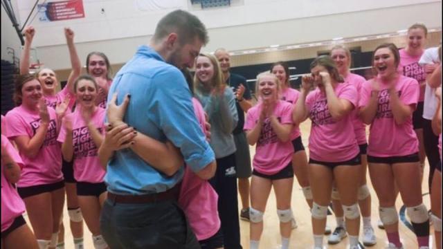 La pareja rodeada por las emocionadas compañeras del equipo de voleibol