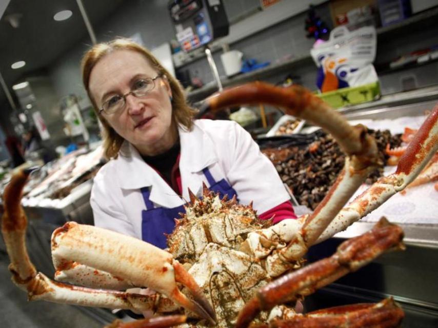 Una pescadera sostiene una centolla en el mercado de la plaza de Lugo (A Coruña)