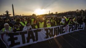 Manifestación de chalecos amarillos en la plaza de la Concordia de París con una pancarta que acusa al Estado de ser la ruina del pueblo.