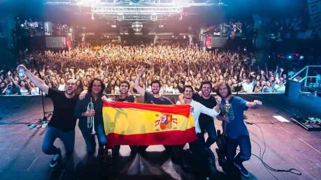 Los miembros de Taburete, con la bandera de España en su concierto de Barcelona.