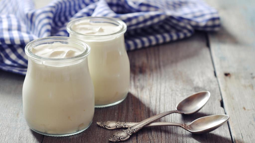 Un par de yogures de marca blanca con sus respectivas cucharillas.