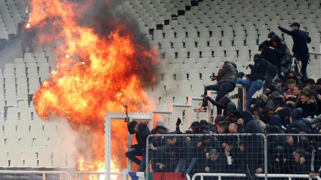 La afición del AEK Atenas lanza bengalas a la del Ajax