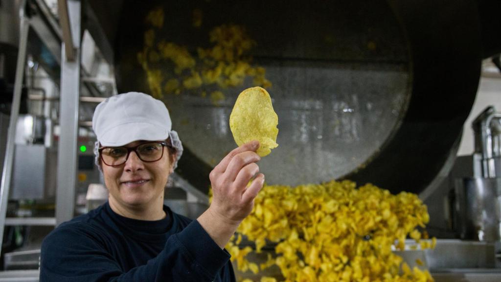 Herminia, empleada de Monti, mostrando una patata recién salida del perol.