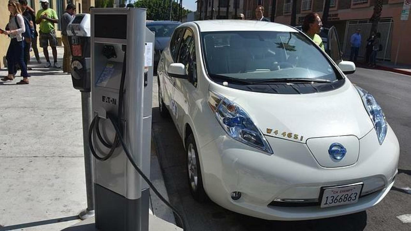 Un conductor carga su coche eléctrico en un punto de recarga.