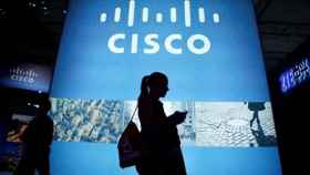 Una usuaria pasa por delante de una representación de Cisco.