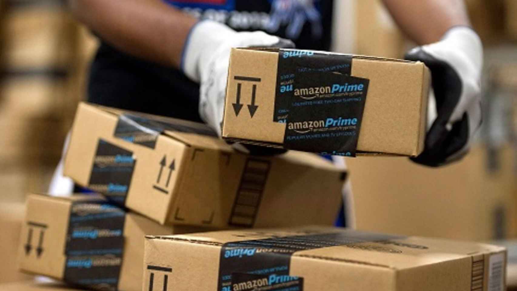 Un empleado de Amazon trabajando con varias cajas con productos enviados por la compañía.