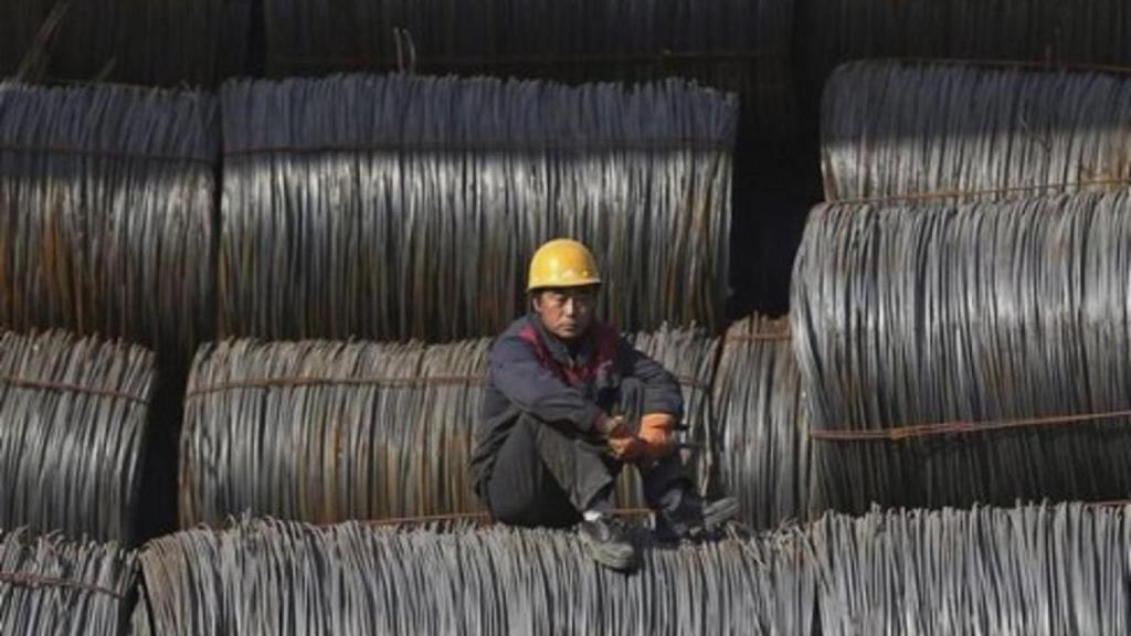 Un trabajador chino sobre bovinas de acero.